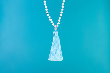 Moon stone mala beads on blue background. Gemstone strand used for keeping count during mantra...