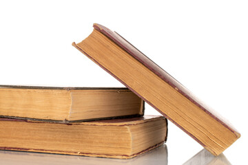 Three old books, macro shot, isolated on a white background.