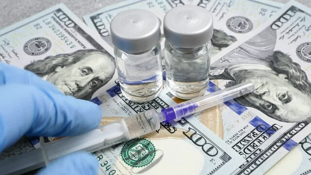 bottles of vaccine, syringes and money, money for purchase and production vaccine against covid-19,  concept