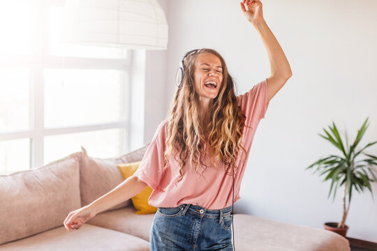 Carefree Happy Single Young Attractive Woman Dancing Alone At Living Room