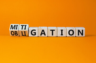 Obligation and mitigation symbol. Turned wooden cubes and changed the concept word obligation to mitigation. Beautiful orange background copy space. Business obligation and mitigation concept.