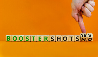 Covid-19 booster vaccine shots yes or no symbol. Doctor turns cubes changes words booster shots no to booster shots yes. Beautiful orange background copy space. Covid-19 booster vaccine shot concept.