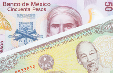 A macro image of a pink, plastic fifty peso bank note from Mexico paired up with a yellow one thousand dong bill from Vietnam.  Shot close up in macro.
