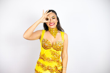 Young beautiful woman wearing carnival costume over isolated white background doing ok gesture shocked with smiling face, eye looking through fingers