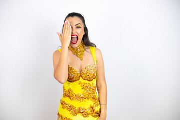 Young beautiful woman wearing carnival costume over isolated white background covering one eye with hand, confident smile on face and surprise emotion.