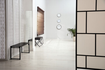 Empty office corridor with benches and window