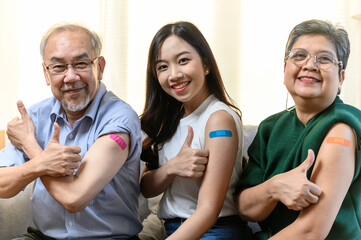 Group of diverse age Asian people family senior showing bandage plaster on arm after received covid...