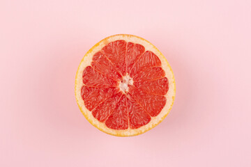 Grapefruit on pink background, top view, flat lay
