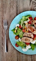 Classic Caesar salad with tomato, chicken and egg