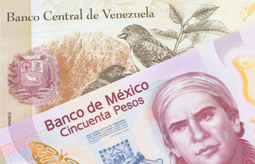 A macro image of a pink, plastic fifty peso bank note from Mexico paired up with a colorful one hundred Bolivar bank note from Venezuela.  Shot close up in macro.