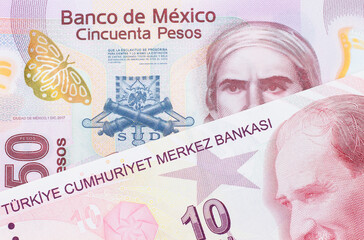 A macro image of a pink, plastic fifty peso bank note from Mexico paired up with a red, ten lira bank note from Turkey.  Shot close up in macro.