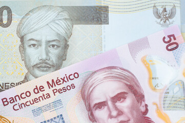 A macro image of a pink, plastic fifty peso bank note from Mexico paired up with a grey two thousand Indonesian rupiah bank note.  Shot close up in macro.