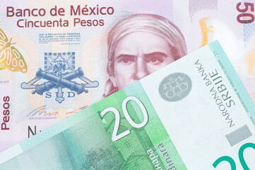 A macro image of a pink, plastic fifty peso bank note from Mexico paired up with a green and white twenty dinar banknote from Serbia.  Shot close up in macro.