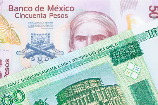 A macro image of a pink, plastic fifty peso bank note from Mexico paired up with a green one hundred ruble note from Belarus.  Shot close up in macro.