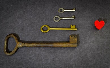 Heart and keys on a dark background. Old keys and a heart. Selection of keys to the heart. A difficult choice in love. valentine's day