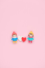 Fototapeta premium two toy dolls with red and white hearts on pink background. cute toy friends with hearts. 14 february, Valentine's day, Love, romance, friendship concept. flat lay. copy space