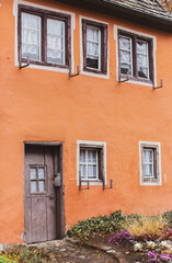 Fototapeta na wymiar Memmingen, Germany - 11.22.2021: hex red house in old town. Medieval architecture. Ancient witch prison. Memmingen landmark. Historical city tour. Travel in Bavaria. Old building with small windows.