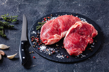 striploin steaks on a black stone plate