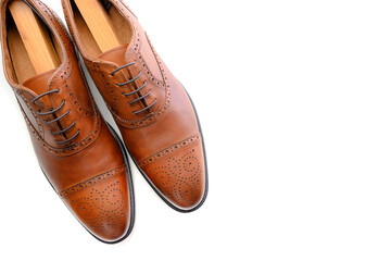 A pair of brown leather shoes on white with copy space