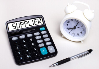 On the light table there is a black calculator with the text SUPPLIER on the scoreboard, a pen and...