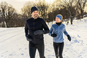 mature couple in the winter running together in nature