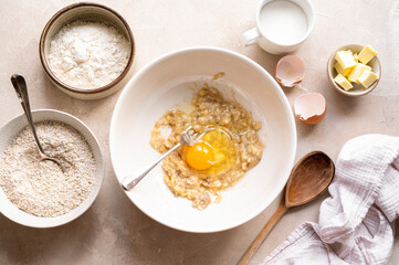 Ingredients for preparing banana cookies and dough on color wooden background