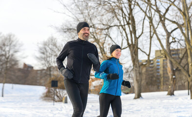 mature couple in the winter running together in nature