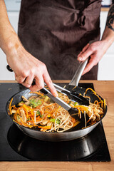 Chef cooking delicious udon wok.