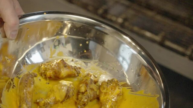 tossing chicken wings in sauce