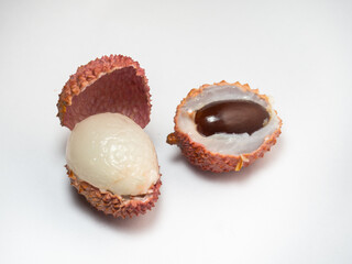 Sliced ​​lychee. Chinese plum. Fruit shell. Purified Lychee. Pieces of juicy fruit on a white background.