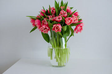 a bunch of pink tulips on the white table