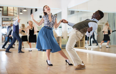 Woman with african man practising charleston dancing