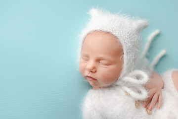 Sleeping newborn baby on a blue background. Photoshoot for the newborn. A few days from birth.