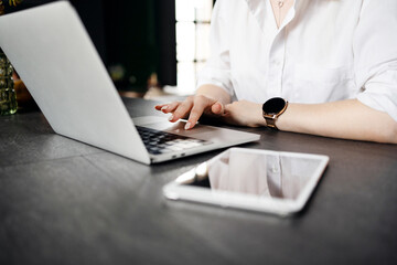 A female financier works in a hotel workplace uses a laptop, communicating with a client.