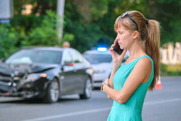 Stressed woman driver talking on mobile phone on street side calling for emergency service after...