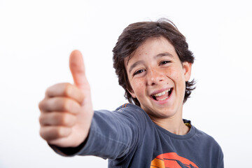 Niño sonriendo con el pulgar hacia arriba. Gesto OK.