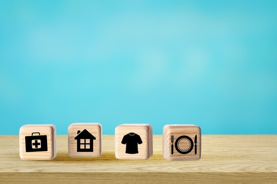 Wooden cube with food Clothing, housing, medicine, four basic human needs on the desk.