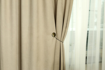 beige curtain folds and white tulle close up photo on window background