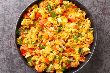 Egg Bhurji Spiced Indian Scrambled Eggs closeup in the plate on the table. Horizontal top view from above