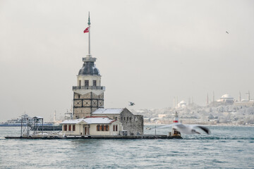 Obraz premium Magnific view of Maiden's Tower (aka Kiz kulesi) in winter day with many snow in Istanbul,Turkey. Istanbul's main attractions. 