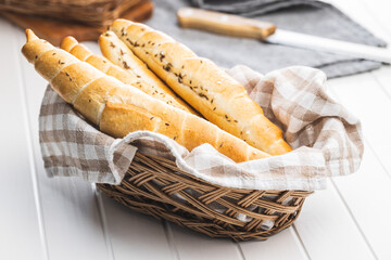 Baked croissant in basket. Crispy bun roll on white table.