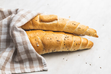 Baked croissant. Crispy bun roll on white table.