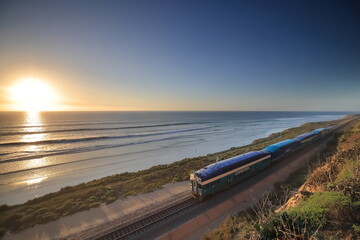 Amtrak trains along the San Diego coastline at dusk - obrazy, fototapety, plakaty