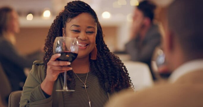 Cheers to a successful first date. Young couple toasting with wine while on a date at a restaurant. Beautiful african woman being social with a man. Having fun and enjoying a romantic dinner