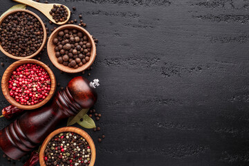 A set of peppers.Collage of different type pepper, Black ,white, pink and allspice peppercornsr, dried chili pepper.Top view. On a black background. free space for your text.
