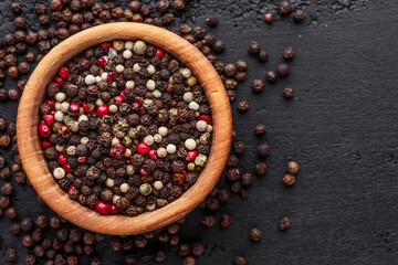 A set of peppers.Collage of different type pepper, Black ,white, pink and allspice peppercornsr, dried chili pepper.Top view. On a black background. free space for your text.