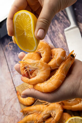 close-up of squeezing lemon on boiled shrimp