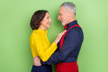 Profile portrait of two peaceful idyllic pensioners hug look eyes enjoy discotheque isolated on green color background