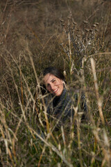 Naklejka na ściany i meble A woman in a smiling attitude through the dry grass