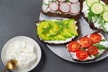 Healthy sandwiches with white cottage cheese, cucumber, arugula, avocado, tomato and radish